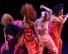 Dancers onstage in top lighting all dressed in various reds